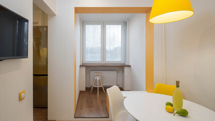 Modern interior of apartment. Fruits and liquor on white table. Small room.