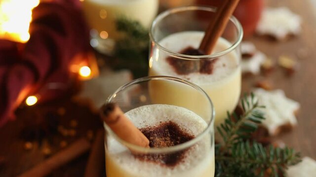Christmas eggnog decorated with ground cinnamon and a cinnamon stick. Traditional festive drink