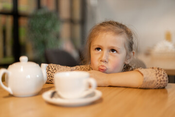 Cute little girl misses in the cafe.