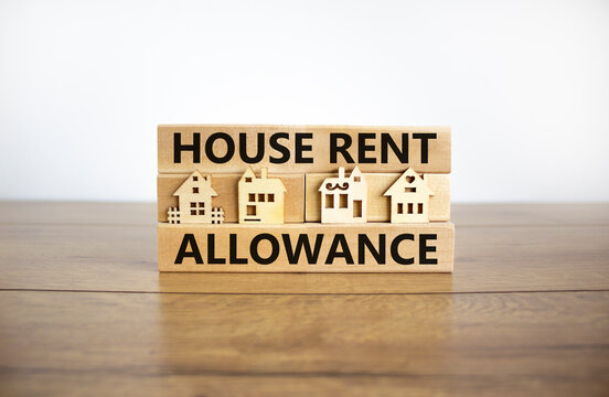 House Rent Allowance symbol. Wooden blocks with words 'House Rent Allowance', miniature houses. Beautiful wooden table, white background, copy space. Business and House Rent Allowance concept.