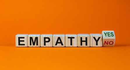 Empathy yes or no symbol. Concept words 'empathy yes' and 'empathy no' on wooden cubes on a beautiful orange background. Psychological and empathy concept, copy space. - obrazy, fototapety, plakaty