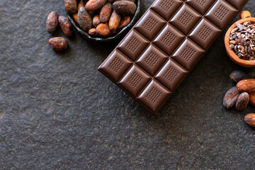 Chocolate, cocoa beans, cocoa slices on a black background