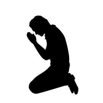 Silhouette of man sitting on her knees praying