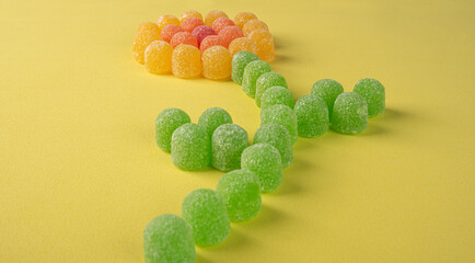 Gummy candy, arrangement of gummy candy in the shape of a flower on a colored surface. selective...