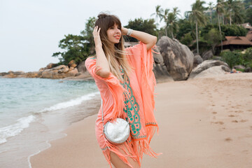 Happy european  woman with long hairs in stylish boho summer dress posing on the tropical beach.