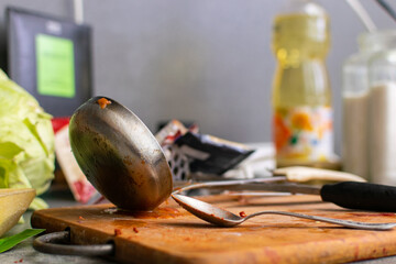 Clutter and chaos on the kitchen table. Uncleaned, dirty kitchen utensils.
