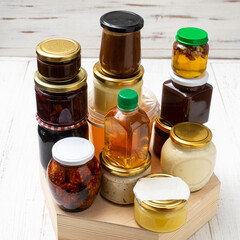Various canned foods in jars on a light wooden background. Organic food.