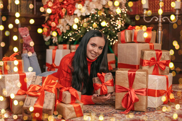A beautiful girl in a New Year's sweater, lying on a mountain of gifts. beautiful girl, many gifts, discounts, sales, black friday, new year, christmas. bokeh