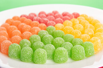 Gummy candy, arrangement of gummy candy seen in detail arranged by color on a white plate on a...