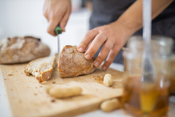 Female hands slicing bread on a cutting board
