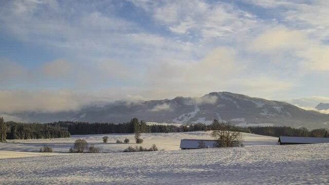 Zeitraffer Allg&auml;uer Vorberge mit Alpspitze im Winter am sp&auml;ten Nachmittag mit Zweischichtwolken bis Sonnenuntergang
