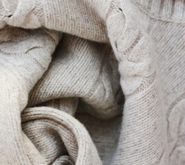Beautiful beige knitted sweater close up view 