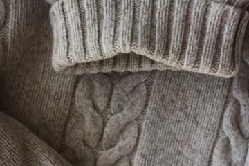 Beautiful beige knitted sweater close up view 