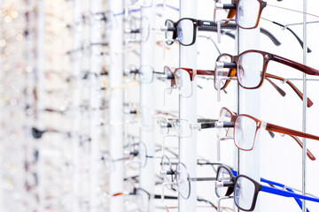 stand with eyeglasses in the store. the choice of spectacles for correction of vision
