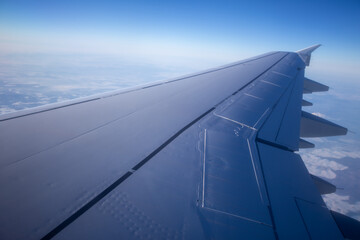 Fototapeta premium Airplane wings flying in midair and view of clouds in the sky