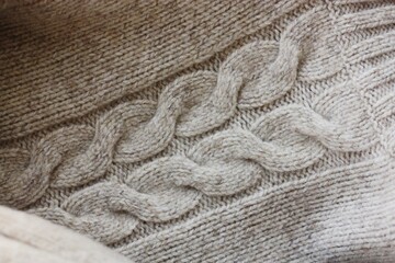 Beautiful beige knitted sweater close up view 