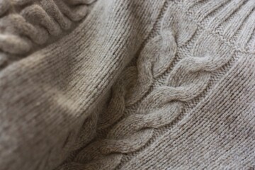 Beautiful beige knitted sweater close up view 