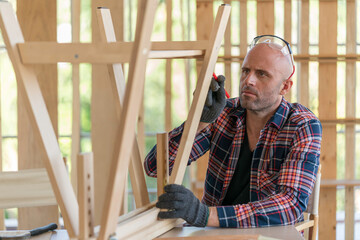 Expereince carpenter builds a modern furniture in workshop