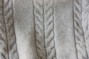 Fototapeta na wymiar Beautiful beige knitted sweater close up view 