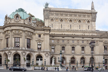 Fototapeta na wymiar View of the Palais Garnier opera from the street Halevy. On the street pedestrians and moving vehicles