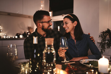 Smiling couple talking together during a candlelit dinner party