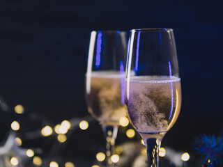 Festive Christmas card, romantic evening, two glasses of champagne on a decorated background