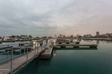 Wooden walkway leading to empty boat docks with cloudy sky in Chicago