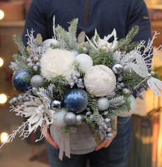 Christmas bouquet in round box. White and blue decor, Christmas tree decorations with fir branches. Gift box for Christmas.