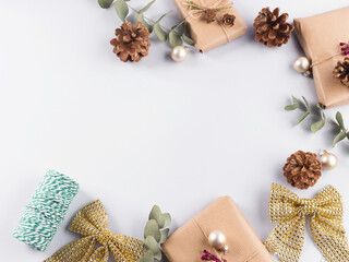 Christmas festive frame with wrapped zero waste presents, bows, pine cones on gray background.