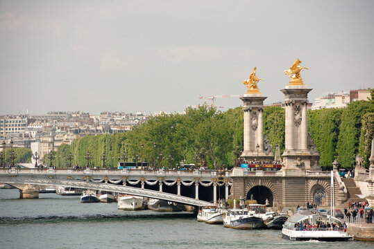  View of the Alexander lll Bridge . By the embankments are moving cars and pedestrians