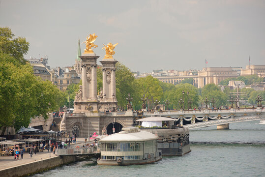  View of the Alexander lll Bridge . By the embankments are moving pedestrians