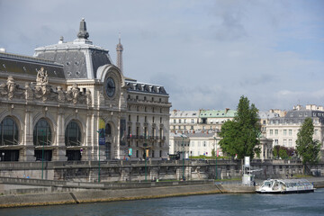 Fototapeta na wymiar View of the Orsay Museum from the Royal Bridge. On the waterfront people walk