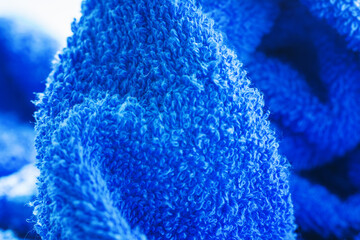 Blue terry towel texture closeup. Soft cotton towel backdrop, fabric background. Selective focus, shallow depth of field.