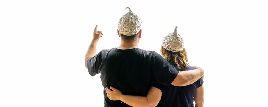 A married couple looks towards the horizon. Both are conspiracy theorists and wear an aluminum foil hat. White background for text free space, banner shape.