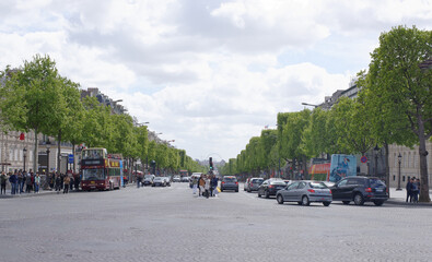 Champs Elysees. On the roadway moving cars, pedestrians-on sidewalks