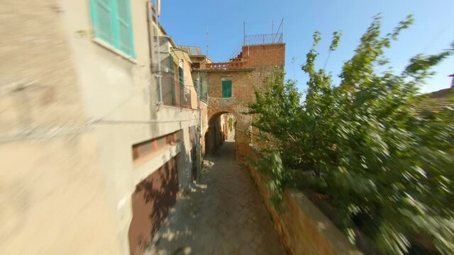 Drone Flying Under Pointed Horseshoe Arch Towards The Beautiful Town Of Sinalunga In Tuscany, Italy. - FPV, aerial