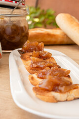 Homemade bread toast with a delicious homemade apple and onion chutney, with cinnamon on a light wooden board. Perfect jam for breakfast. Breakfast, cooking, food concept.