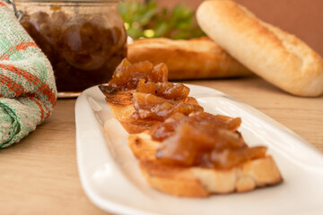 Homemade bread toast with a delicious homemade apple and onion chutney, with cinnamon on a light wooden board. Perfect jam for breakfast. Breakfast, cooking, food concept.