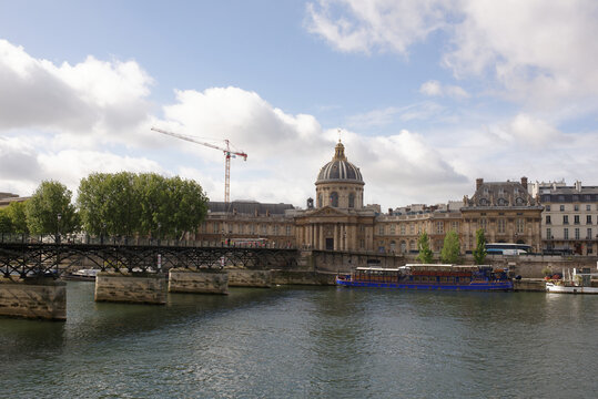  View of the Institute of France. On the Bridge of Arts citizens walk