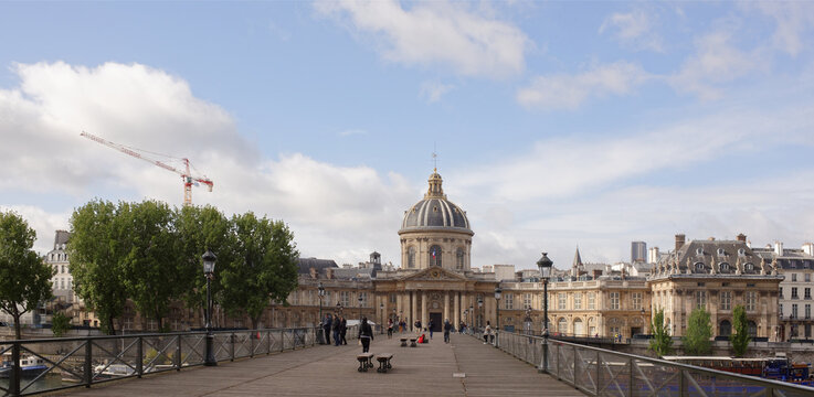 View of the Institute of France. On the Bridge of Arts citizens walk