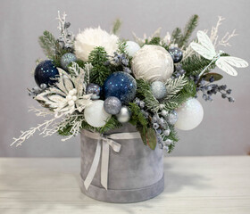 Christmas bouquet in round box. White and blue decor, Christmas tree decorations with fir branches. Gift box for Christmas.