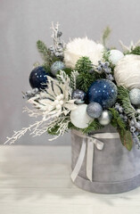 Christmas bouquet in round box. White and blue decor, Christmas tree decorations with fir branches. Gift box for Christmas.