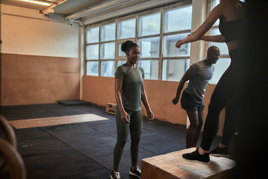 Diverse group of fit people doing box jumps together