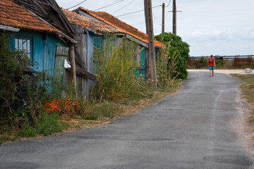 Fototapeta na wymiar une rue avec des maisons abandonnées. Une ville fantôme avec des vieilles maisons en bois abandonnées. Un touriste visitant une ville fantôme. Saint-Trojan-les -Bains