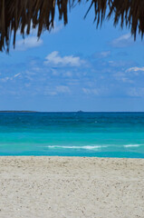 Turquoise caribbean sea on Varadero beach in Cuba, peninsula Hicacos, an excursion ship on horizon, blue sky with clouds background, copy space