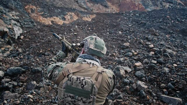 Slow motion of soldiers aiming their assault rifles in mountains.