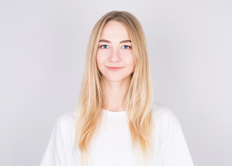 Fototapeta premium Happy cheerful young blonde teen looking at camera with joyful and charming smile.