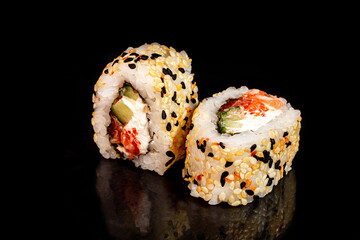 Sushi Sets Uramaki, California, Philadelphia, on a white plate. Festive, New Year concept. Against a dark reflective background.