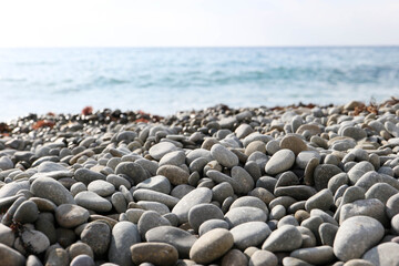 smooth pebbles stones on the beach with the sea on the background