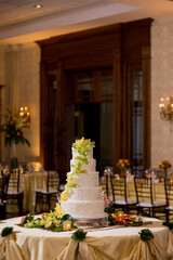 white tiered wedding cake with citrus and greenery